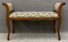 A contemporary stained ash window seat or duet stool with scroll motifs and needlework upholstery on