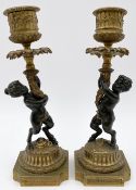 A pair of 19th century French bronze and ormolu candlesticks, male and female satyrs, with maker's