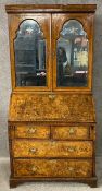 An early Georgian walnut crossbanded and featherbanded bureau bookcase, the upper section with