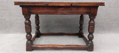 An 18th century oak draw leaf dining table on turned stretchered supports. L.122 / L.213 (ext.) H.77