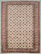 A contemporary handmade woollen Shirvan carpet with repeating stylised flowerhead motifs across a