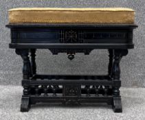 A 19th century walnut and ebonised Aesthetic style piano stool with lift up upholstered seat. H.44