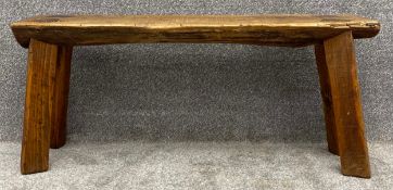 A primitive style tree trunk bench on square splayed supports. H.41 W.91 D.26cm