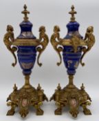 A pair of gilt metal Italian Brevettato porcelain urns with hand painted decoration and maker's mark