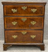 A small Georgian yewwood and crossbanded chest of drawers probably with original brassware raised on
