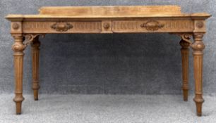 A late Victorian carved oak console or serving table fitted with frieze drawers raised on fluted