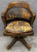 A C.1920 oak framed Hillcrest reclining swivel chair with leather and studwork upholstery and