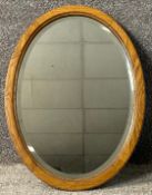 A mid century oak mirror with bevelled plate. H.59 W.44cm.