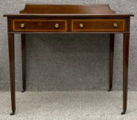 An Edwardian mahogany and satinwood crossbanded writing table with inset leather top and frieze