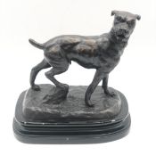 A spelter figure of a standing dog on a naturalistic base. H.26 W.24cm.