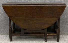 An 18th century country oak drop flap dining table fitted with frieze drawer and with gate-leg