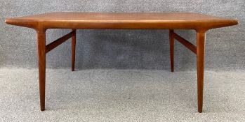 A mid century Danish teak extending dining table with two integrated leaves in the style of Johannes