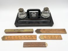 A Victorian lacquered inkwell with three cut glass bottles, two with embossed brass lids, along with