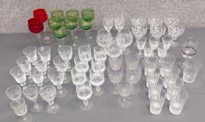 A large collection of crystal and other glasses comprising seven green hock, a pair of red wine,