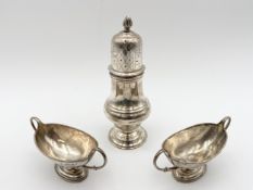 A pair of silver twin handled salts and a silver sugar caster all bearing English hallmarks. H.18 (