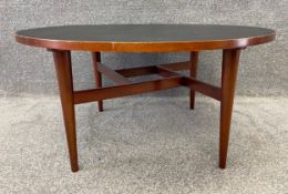 A mid century teak coffee table by Gordon Russell, on tapering supports with interlocking stretchers