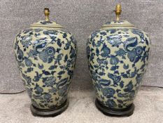 A pair of Oriental style baluster vase lamps on shaped wooden bases. H.60cm (each)