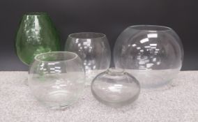 A collection of four globular glass florists vases, along with one large wine glass shaped green