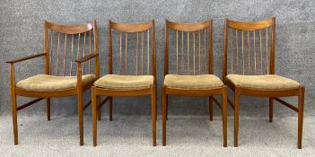 A set of four mid century Danish teak dining chairs with splayed spindle back design and a drop in