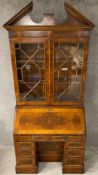 A Georgian style yewwood bureau bookcase with crossbanding and feather banded inlay, the upper