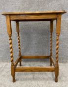 An Edwardian oak side table on slender barley twist legs below a bevelled and shaped rectangular