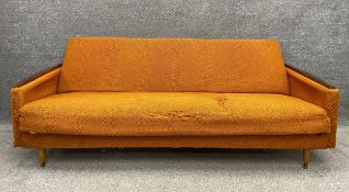 A mid century Danish style daybed with teak armrests and tapering feet, with original orange wool