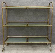 A vintage steel industrial style trolley with removable frosted glass shelves fitted with braked