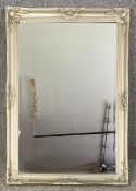 A contemporary wall mirror with a bevelled plate in a foliate silvered frame. H.104 W.74cm