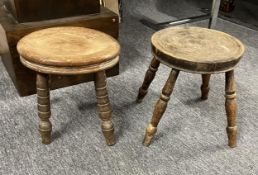 Two elm seated milking stools. H.26cm