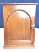 A mid 19th century mahogany cabinet with arched panel door enclosing drawers. H.43 W.33 D.33cm