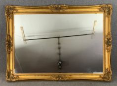 A large wall mirror with bevelled plate in gilt foliate scrolling frame. H.153cm x W.213cm