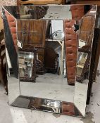 A contemporary wall mirror in a glazed frame. H.96 W76cm