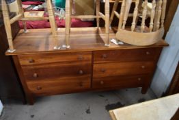 A contemporary teak chest of drawers. W.156cm