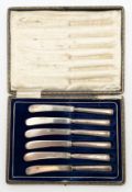 A set of six late 19th/early 20th century butter knives with hallmarked silver handles, in a leather