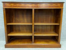 A Regency Sheraton style mahogany open bookcase with ribband and husk marquetry, and crossbanded and