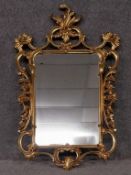 A contemporary Rococo wall mirror in moulded gilt frame. H.106 W.57cm