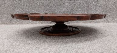 A mahogany lazy suzan with a shallow moulded pie crust tray top and a shaped edge, raised on a