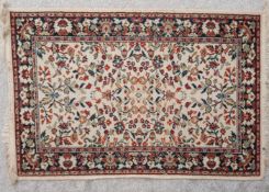 A Persian rug with all over flowerhead motifs on a biscuit ground. L.160 D.82cm