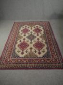 A woollen early machine made rug from Central Asia, with central lozenge medallions on a biscuit