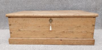 A C.1900 pine trunk/chest on a plinth base, with key. H.34 W.92 D.52cm