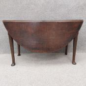 A mid Georgian oak drop flap dining table fitted with frieze drawer on gateleg pad foot supports.