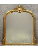 A large contemporary gilt Rococo style overmantel mirror with a scrolling foliate cresting and an