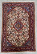 A Persian Jozan rug with a foliate design over a biscuit field, the central cartouche and borders