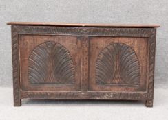 An 18th century oak coffer with carved panels raised on stile supports. H.61 W.107 D.50cm