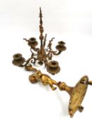 An ornate French gilt brass table candelabra with a putto standing on one foot on a fluted base with