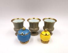 Three gilt Wedgwood egg cups with duck egg interiors, and two miniature covered sugar pots by