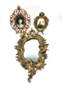 A Rococo style gilt metal wall mirror with birds and a scrolling foliate design, along with two gilt