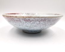 A salt-glazed studio pottery dish with mottled pale blue on a pink ground, with maker's mark to