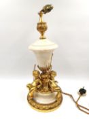 An ormolu mounted marble table lamp flanked by three putti/cherubs holding a trident and paddles. (