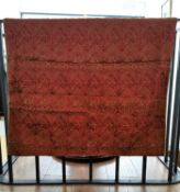A burgundy silk wall hanging backed with hessian and embroidered with Arabic text, possibly verses